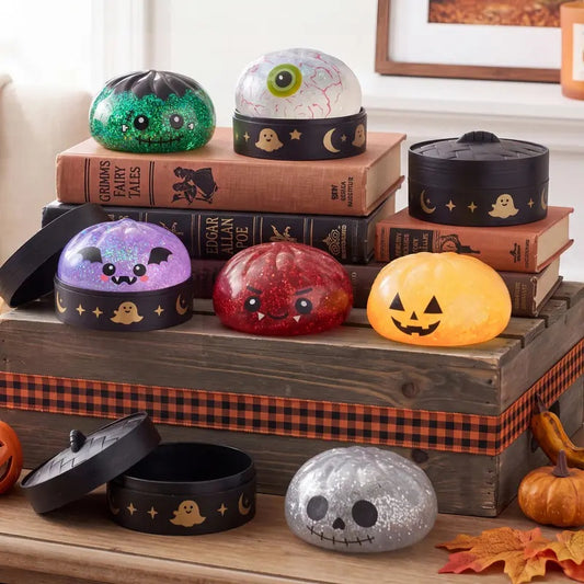 Halloween dumpling squishy characters displayed with steamer-style cases
