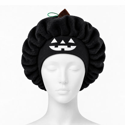 Black plush pumpkin sleep cap on a mannequin head with the jack-o'-lantern face at the front